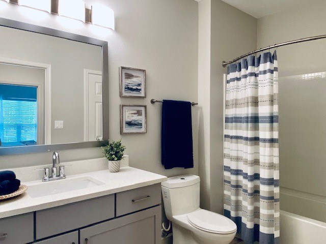 a bathroom with a toilet and a sink and a mirror at Mainstreet Apartments, Clearwater